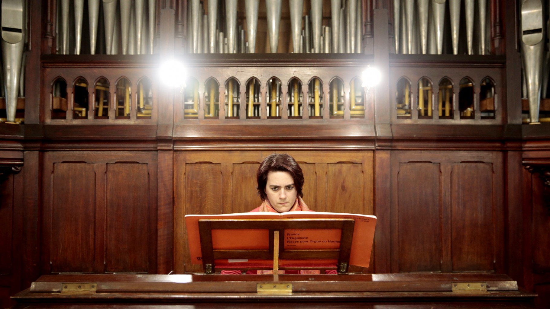 Imagem de um organista tocando um órgão de tubos